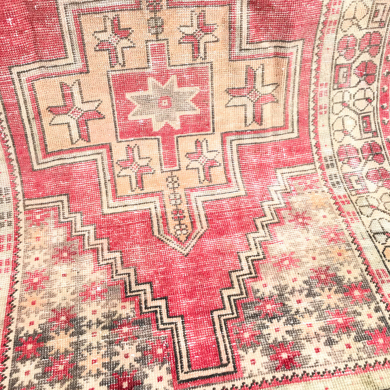 This handwoven vintage Turkish rug has beautiful neutral and light gold accents. Background color is a deep salmon pink / red. Niğde. 